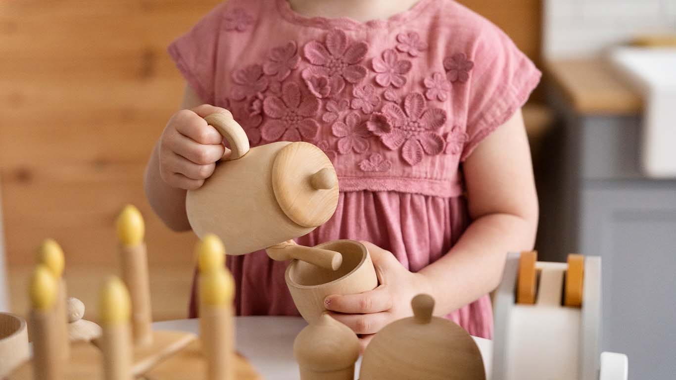 kind 3 jaar speelt met houten speelgoed